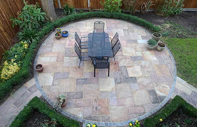 Beautiful circular paver patio installation surrounded by garden